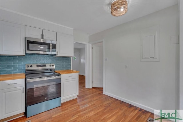 kitchen featuring wooden counters, appliances with stainless steel finishes, decorative backsplash, white cabinets, and light hardwood / wood-style floors