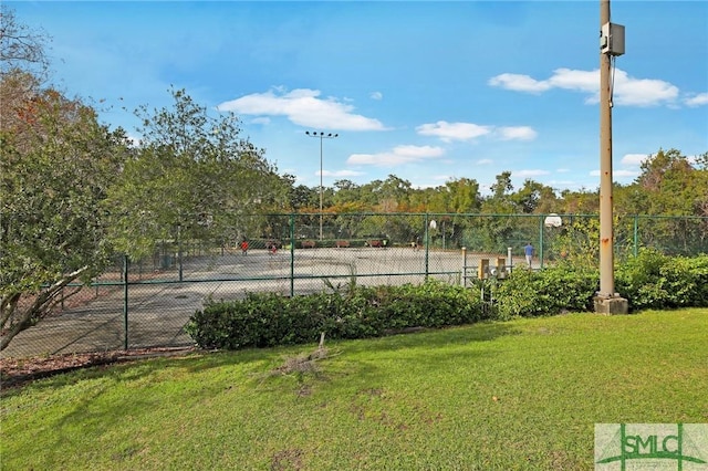 view of tennis court with a lawn