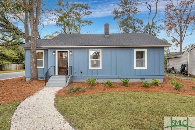 bungalow-style home featuring a chimney, board and batten siding, crawl space, a front yard, and roof with shingles