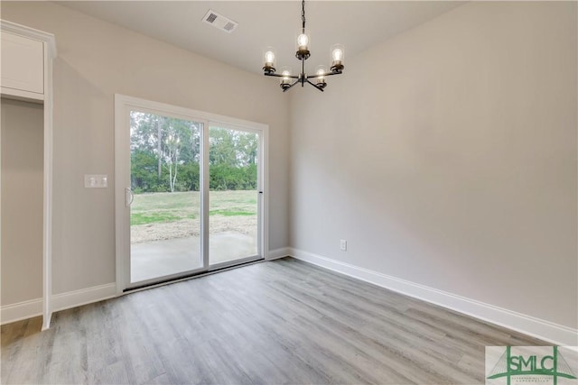 unfurnished dining area featuring light hardwood / wood-style flooring and a chandelier