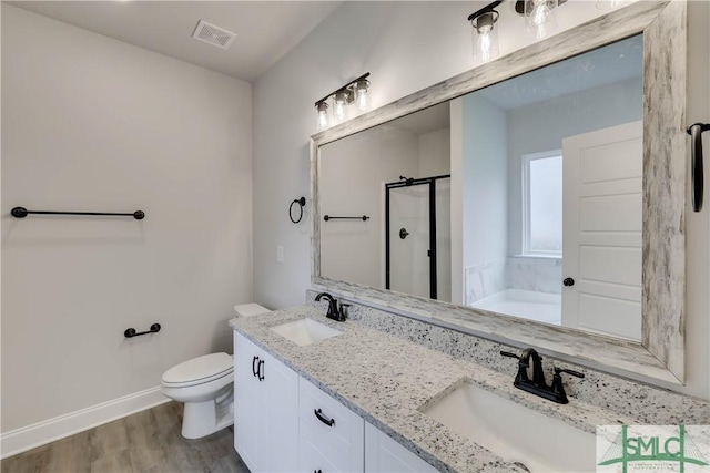 full bathroom featuring independent shower and bath, vanity, wood-type flooring, and toilet