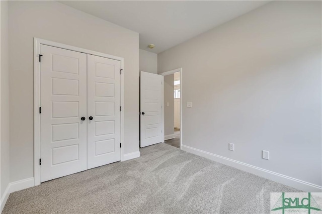 unfurnished bedroom featuring light colored carpet and a closet