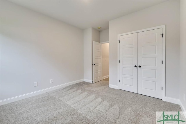 unfurnished bedroom with a closet and light colored carpet