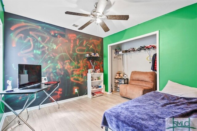 bedroom with ceiling fan, wood-type flooring, and a closet