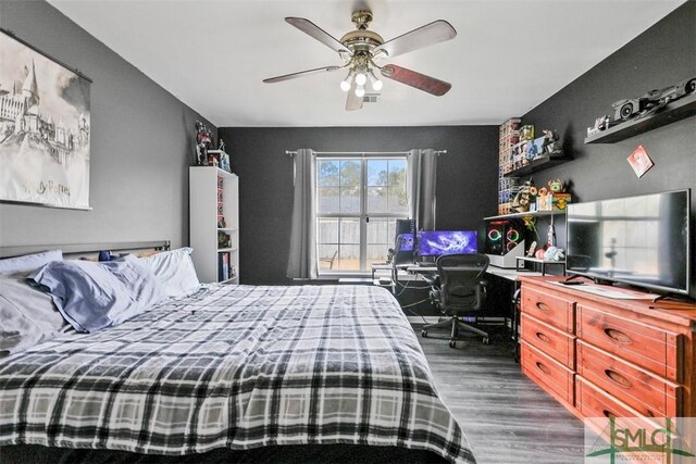 bedroom with dark hardwood / wood-style floors and ceiling fan