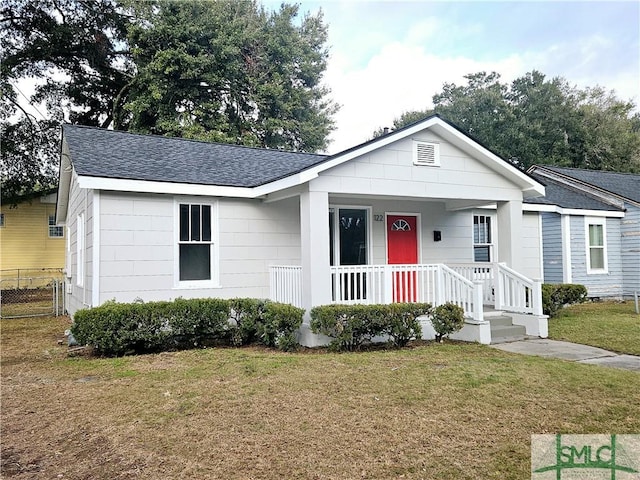 ranch-style home with covered porch and a front lawn