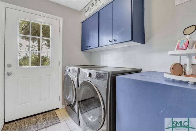 laundry area with cabinets, light tile patterned floors, and washing machine and clothes dryer