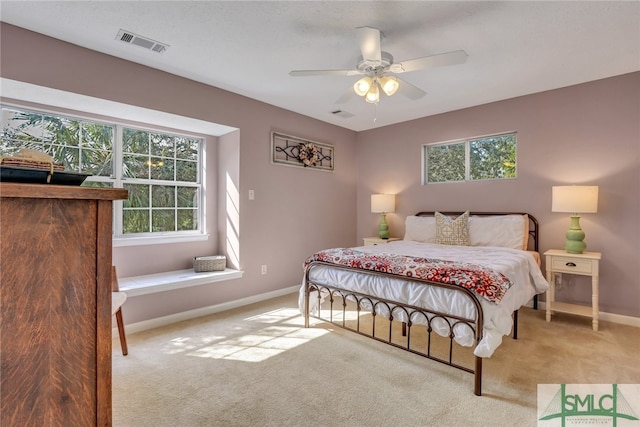 carpeted bedroom with multiple windows and ceiling fan