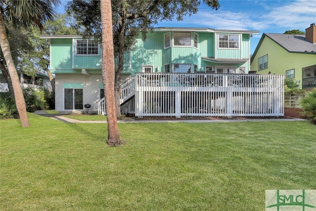 rear view of property with a lawn and a wooden deck