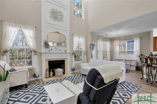 bedroom with light hardwood / wood-style flooring, a high ceiling, and a notable chandelier