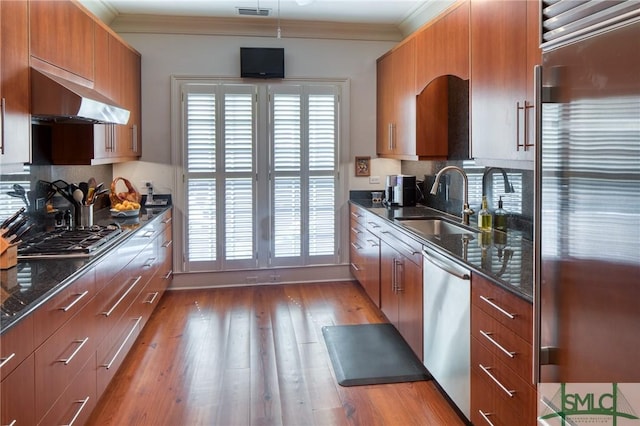 kitchen with backsplash, a healthy amount of sunlight, crown molding, and stainless steel appliances