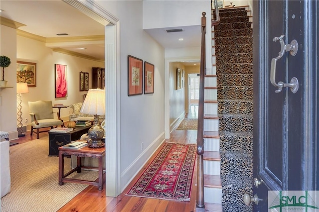 hallway featuring wood-type flooring and ornamental molding