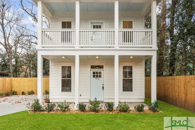 view of front of home with a front yard and a balcony