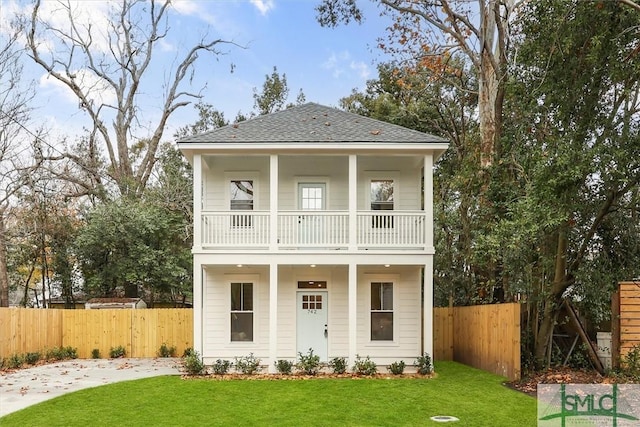 view of front facade with a balcony and a front lawn