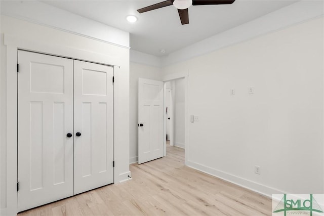 unfurnished bedroom featuring ceiling fan, light hardwood / wood-style floors, and a closet