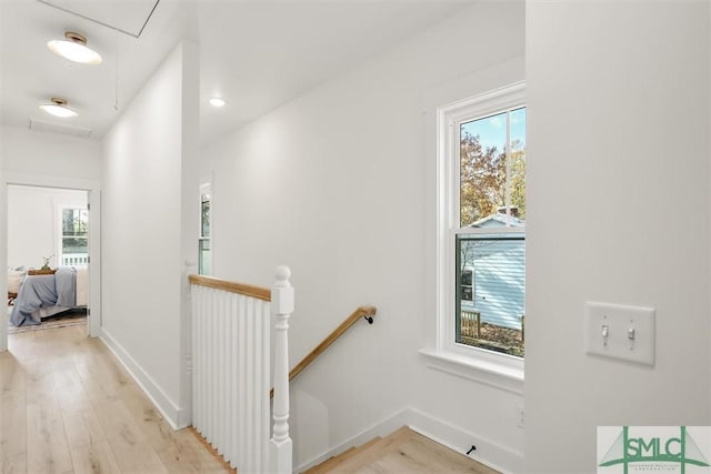 hall with a healthy amount of sunlight and light wood-type flooring