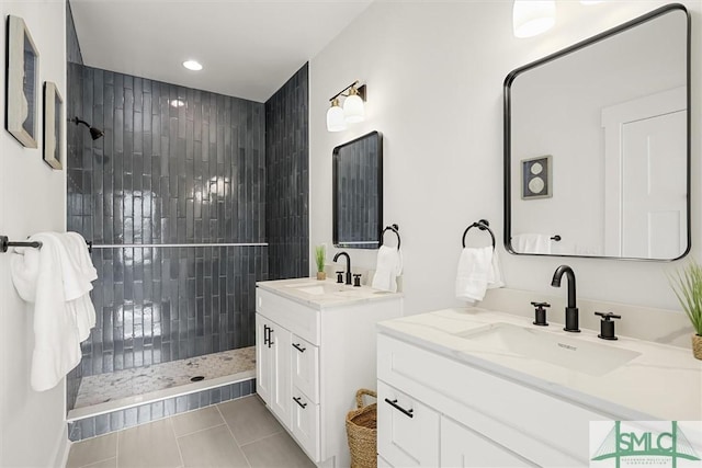 bathroom with tiled shower, vanity, and tile patterned floors