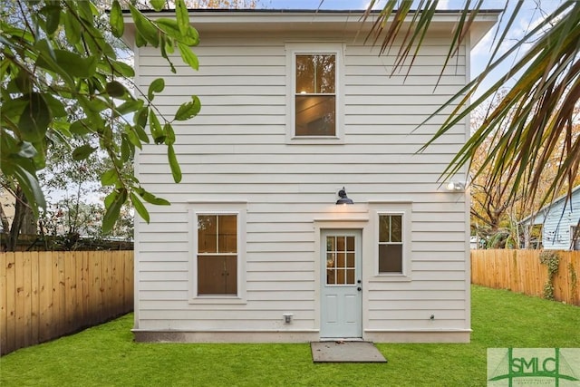 rear view of property with a yard