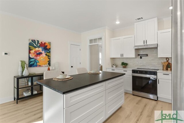 kitchen with white cabinetry, backsplash, stainless steel electric range oven, and light wood-type flooring