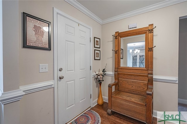 foyer entrance with hardwood / wood-style floors, a notable chandelier, and ornamental molding