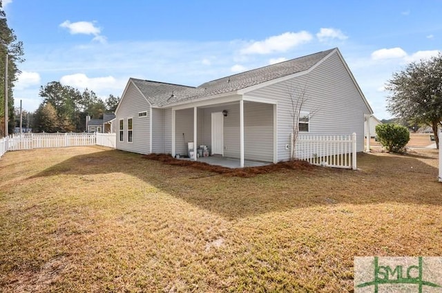 back of house with a lawn and a patio