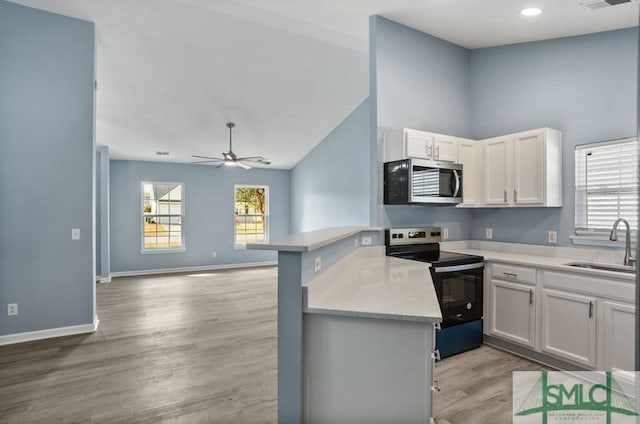 kitchen featuring white cabinets, sink, electric range, light wood-type flooring, and kitchen peninsula