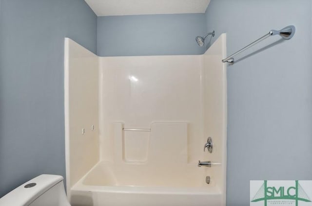 bathroom featuring shower / bathing tub combination and toilet