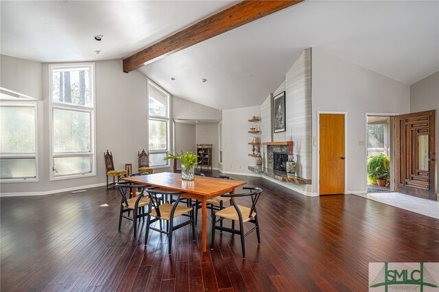 dining room with a fireplace, vaulted ceiling with beams, and hardwood / wood-style flooring