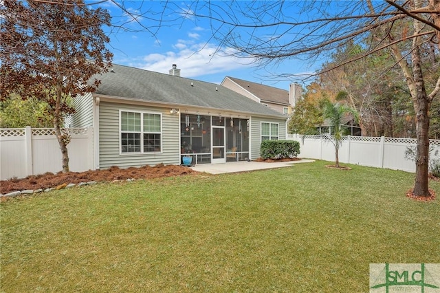 rear view of property featuring a patio, a sunroom, and a lawn