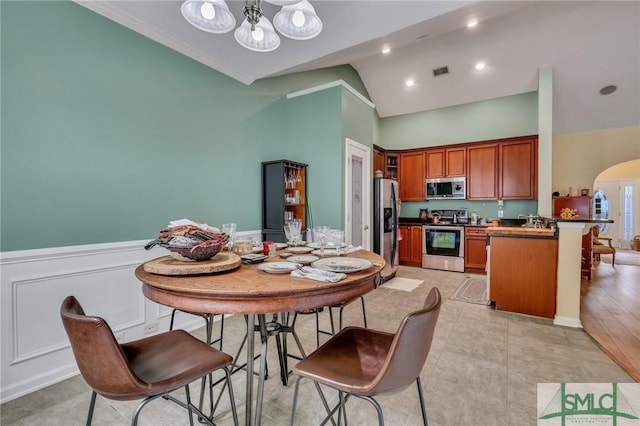 dining space featuring high vaulted ceiling