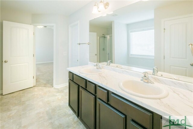 bathroom with a shower with door, vanity, and a notable chandelier