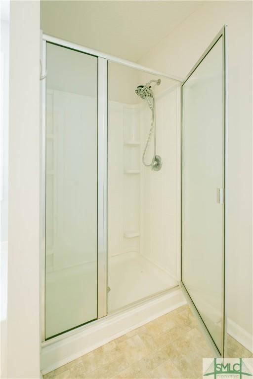 bathroom featuring a shower with shower door