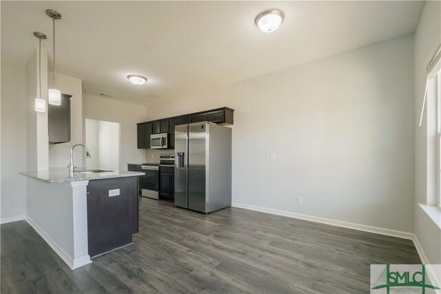 kitchen with kitchen peninsula, sink, stainless steel appliances, and dark wood-type flooring