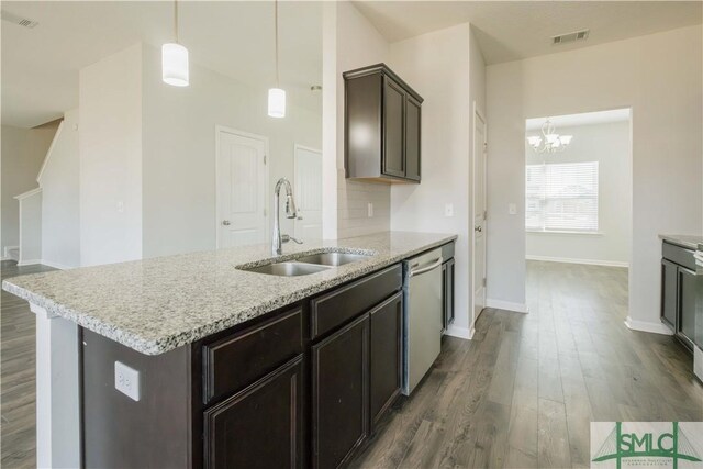 kitchen with dishwasher, sink, dark wood-type flooring, a notable chandelier, and an island with sink