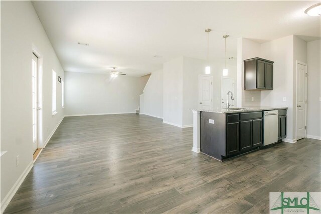 kitchen with sink, ceiling fan, light stone countertops, decorative light fixtures, and dark hardwood / wood-style flooring