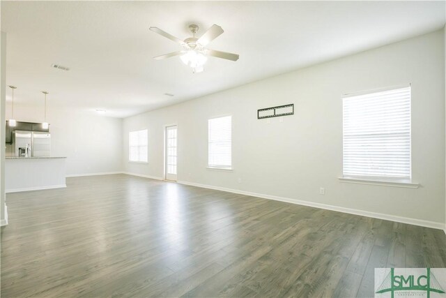 unfurnished living room with ceiling fan and dark wood-type flooring