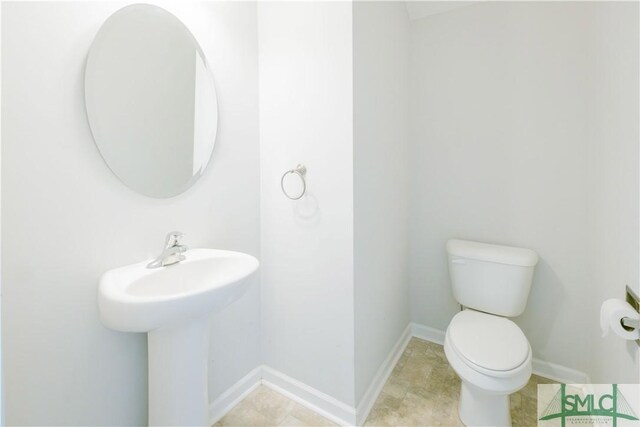 bathroom featuring tile patterned flooring, toilet, and sink