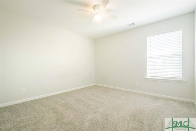 spare room featuring light carpet and ceiling fan