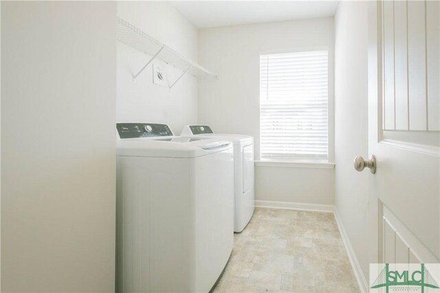 clothes washing area with washing machine and dryer and a wealth of natural light