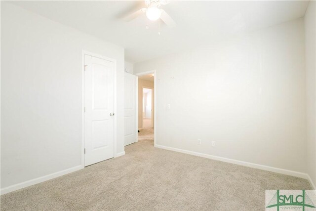 empty room featuring ceiling fan and light colored carpet