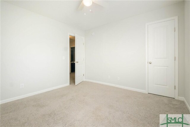 carpeted spare room with ceiling fan