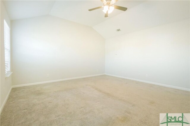 carpeted empty room with ceiling fan and vaulted ceiling