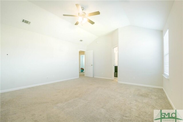 unfurnished room featuring light colored carpet, vaulted ceiling, and ceiling fan