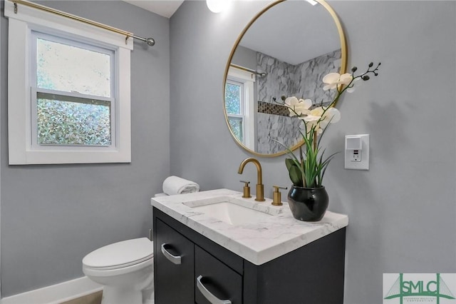 bathroom featuring vanity, toilet, and a wealth of natural light