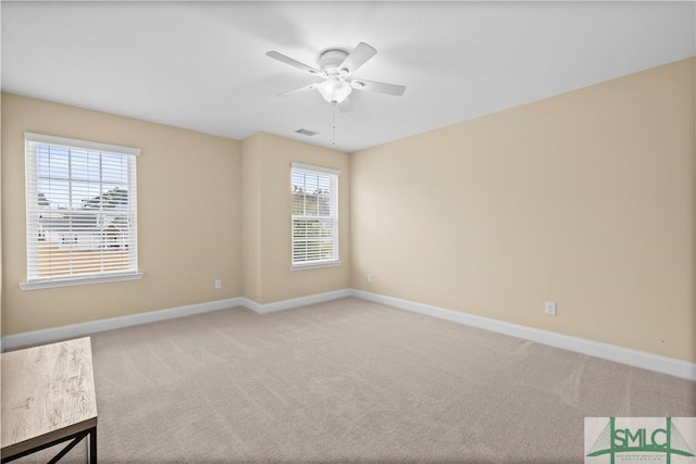 carpeted empty room with plenty of natural light and ceiling fan