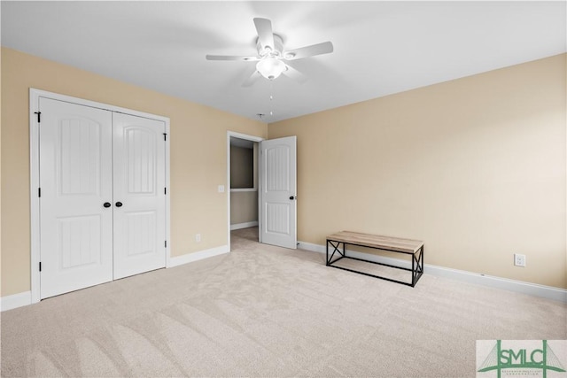 unfurnished bedroom featuring light carpet, a closet, and ceiling fan