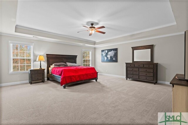 carpeted bedroom featuring a tray ceiling, ceiling fan, and ornamental molding