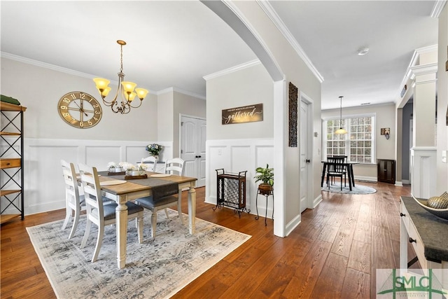 dining area featuring a notable chandelier, dark hardwood / wood-style flooring, and ornamental molding