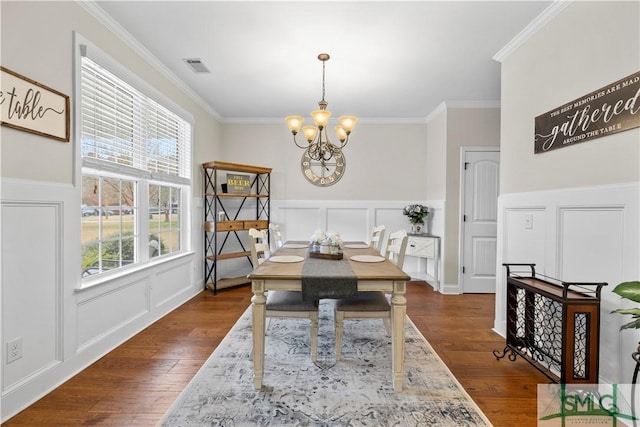 dining space with a chandelier, dark hardwood / wood-style flooring, and crown molding