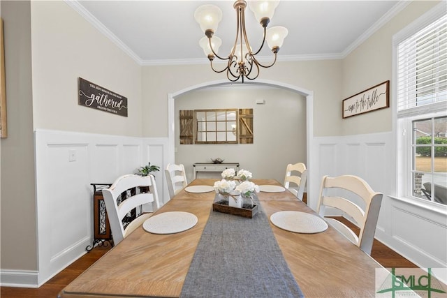 dining room featuring hardwood / wood-style floors, crown molding, and an inviting chandelier